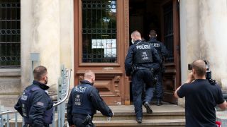 Symbolbild: Polizisten gehen in das Potsdamer Amtsgericht. (Quelle: dpa/S. Stache)