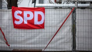 Eine Fahne der SPD ist an einem Zaun in Cottbus angebracht. (Quelle: dpa/Andreas Franke)