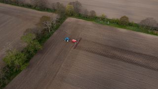 Ein Traktor mit einem Saatstreuer auf einem Feld bei Stahnsdorf in Brandenburg. (Quelle: dpa/Rainer Keuenhof)