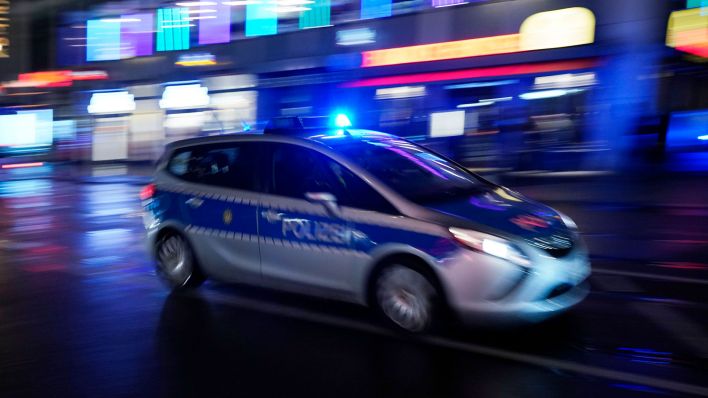 Ein Polizeiauto bei einer Einsatzfahrt mit Blaulicht. (Quelle: dpa/Thomas Bartilla)