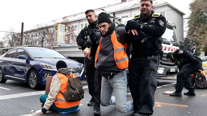 Polizisten tragen einen Teilnehmer einer Sitzblockade auf der Prenzlauer Allee von der Strasse. (Quelle: dpa/Carsten Koall)