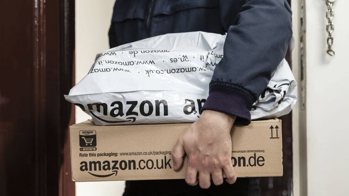 Paketbote übergibt zwei Amazon Pakete (Quelle: dpa)