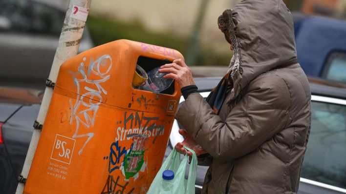 Symbolbild: Eine Flaschensammlerin steht an einem Muelleimer. (Quelle: dpa/Joko)