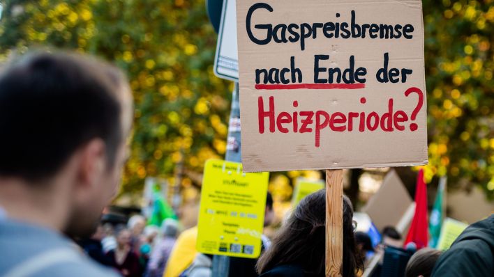 Archivbild: «Gaspreisbremse nach Ende der Heizperiode?» steht auf dem Schild einer Teilnehmerin einer Demonstration auf dem Schlossplatz geschrieben. (Quelle: dpa/C. Schmidt)