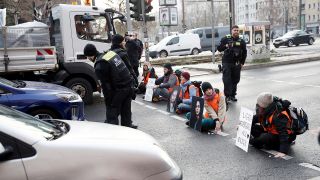 Aktivisten halten Schilder sitzen auf der Prenzlauer Allee. Neben dem Protest für mehr Umweltschutz demonstrierten die Teilnehmer auch gegen die Festnahme von anderen Aktivisten. (Quelle: dpa/C. Koall)