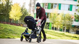 Symbolbild: Ein Vater geht in Berlin mit einem Kinderwagen spazieren. (Quelle: dpa/C. Klose)