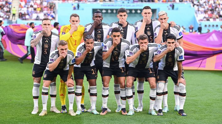 Die Spieler der deutschen Nationalmannschaft halten sich beim Teamfoto den Mund zu (Quelle: IMAGO/Ulmer/Teamfoto)