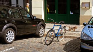 Symbolbild:Ein Fahrrad parkt zwischen Autos.(Quelle:imago images/Steinach)