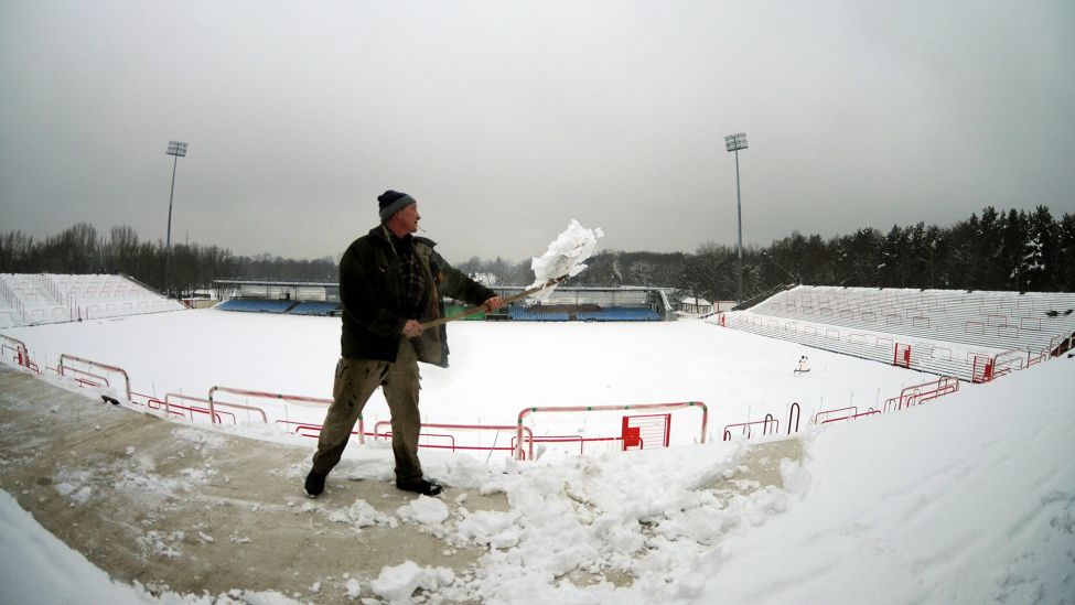 Ein Helfer beim Umbau des Stadions an der Alten Försterei schippt Schnee (imago images/Matthias Koch)