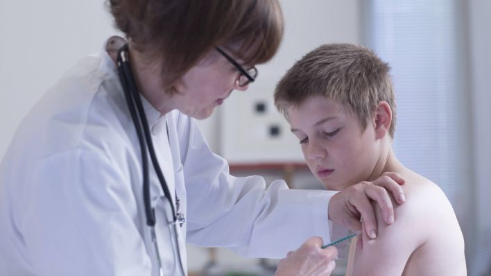 Ärztin verabreicht einem Jungen eine Impfspritze (Bild: imago images/Westend61)