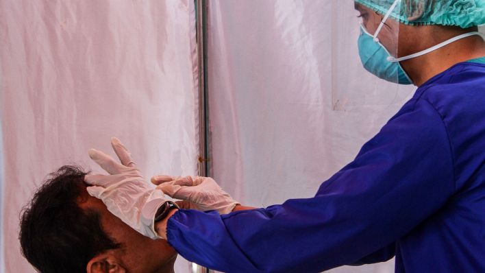 Symbolbild: Ein Mann wird auf Coronavirus getestet (IMAGO/Algi Febri Sugita)