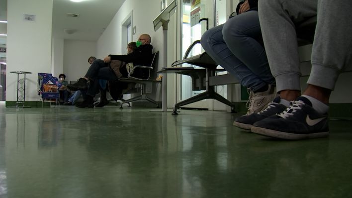 Menschen sitzen in der Arztpraxis und warten auf den Arzt (Quelle: 2022)