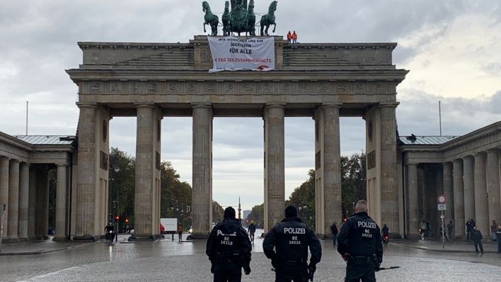 Aktivisten von "Letzte Generation" haben das Brandenburger Tor besetzt und ein Banner von der Quadriga entrollt. (Quelle: rbb)