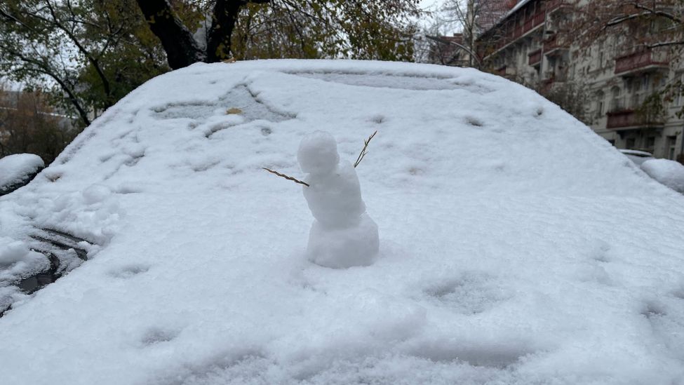 Ein kleiner Schneemann auf der Motorhaube eines Autos in Berlin. (Quelle: rbb)