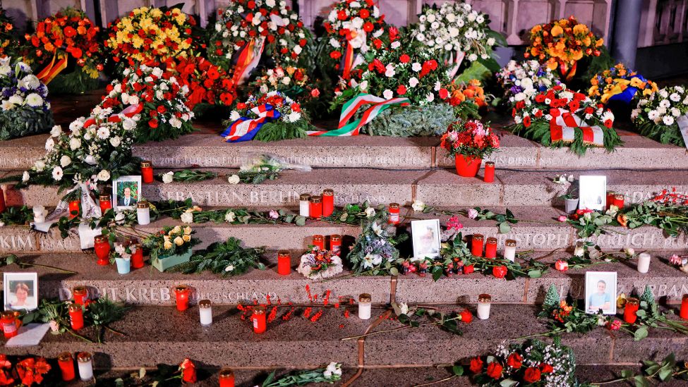 Blumen und Kerzen wurden am 19.12.2021 am Mahnmal "Der Riss" zum Gedenken an die Opfer des Terroranschlags auf den Weihnachtsmarkt 2016 am Breitscheidplatz niedergelegt. (Quelle: dpa/Hannibal Hanschke)