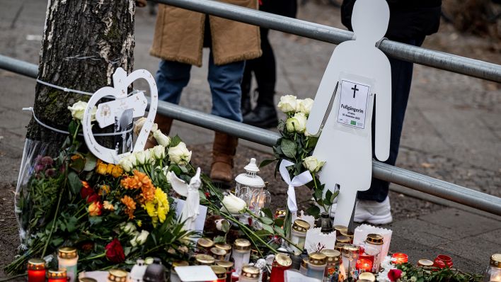 Kerzen und Blumen liegen am 18.12.2022 bei der Mahnwache für die getötete 15-jährige Fußgängerin am Unglücksort in Berlin-Steglitz. (Quelle: dpa/Fabian Sommer)