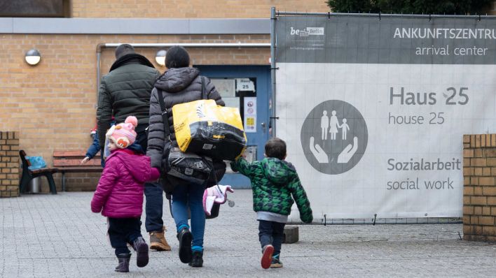 Ein Flüchtling geht mit seiner Familie auf dem Gelände der Erstaufnahmeeinrichtung des Landesamtes für Flüchtlingsangelegenheiten (LAF) in Reinickendorf. (Quelle: dpa/Paul Zinken)
