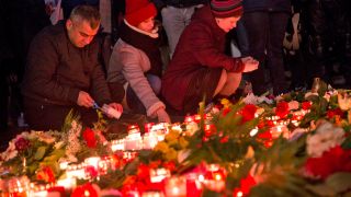 Menschen legen einen Tag nach dem Anschlag auf dem Weihnachtsmarkt am Breitscheidplatz am 19.12.2016 Blumen nieder und zünden Kerzen an. (Quelle. dpa/Emmanuele Contini)
