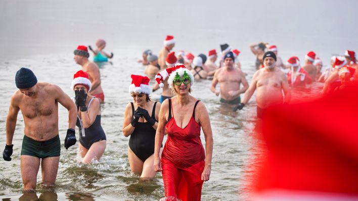 Mitglieder des Vereins "Berliner Seehunde" baden beim Weihnachtsbaden im Orankesee zwischen Eisschollen.(Quelle:dpa/C.Gateau)
