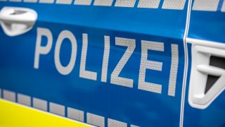 Symbolbild:Schriftzug Polizei in Nahaufname an einem Polizeiwagen.(Quelle:dpa/A.Gora)