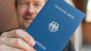 Symbolbild:Ein Reichsbürger zeigt seinen "Deutsches Reich-Reisepass".(Quelle:dpa/P.Seeger)