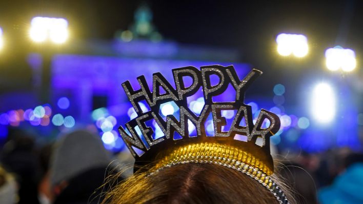 Symbolbild:Kopfschmuck mit dem Wortlaut "Happy New Year" ist bei der Silvesterparty am Brandenburger Tor zu sehen.(Quelle:dpa/J.Carstensen)