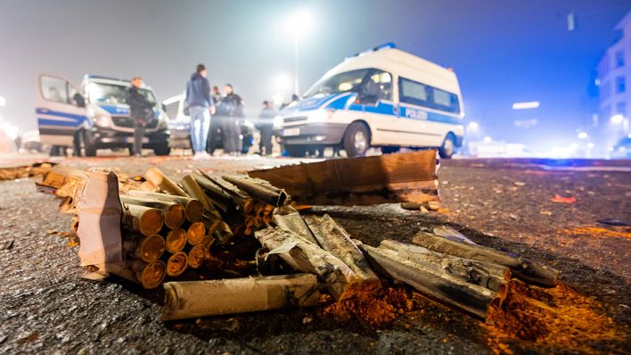 Symbolbild: Ausgebrannt Böller liegen vor einem Polizeiauto. (Quelle: dpa/A. Arnold)