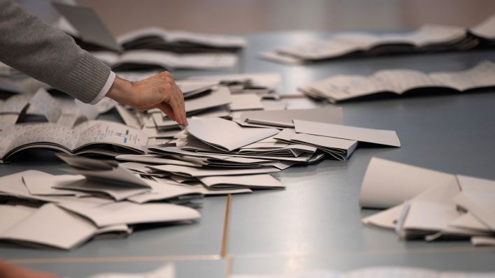 Wahlhelfer:innen zählen in einem Wahllokal Stimmzettel. (Quelle: dpa/Sebastian Gollnow)