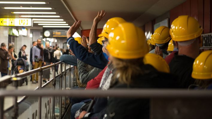Die Mitfahrer winken den Wartenden am Bahnsteig zu. (Quelle: dpa/Andrea Warnecke)
