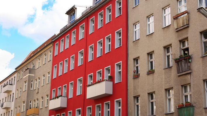 Symbolbild: Ein rotes Mietshaus steht in Berlin Schoeneberg zwischen anderen, grauen Haeusern. (Quelle: dpa/W. Steinberg)