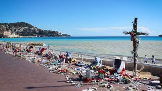 Archivbild: Blumensträuße und ein aufgestelltes Kreuz an der Strandpromenade, nach den Terroranschlägen von Nizza 2016. (Quelle: dpa/abaca)