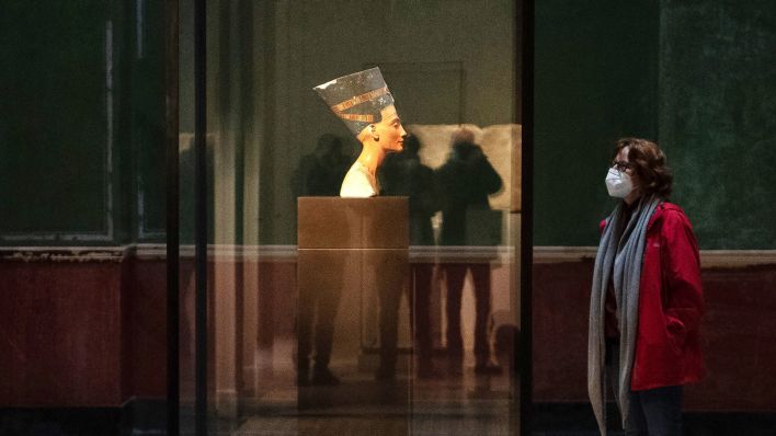 Archivbild: Besucher mit Gesichtsmasken stehen im Neuen Museum an der Büste der Nofretete. (Quelle: dpa/P. Zinken)