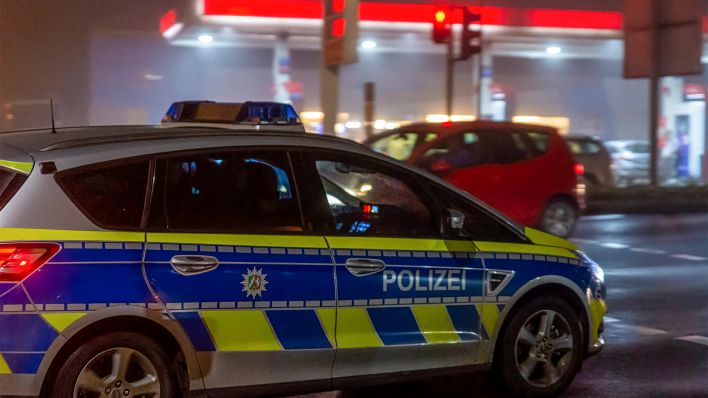 Symbolbild: Ein Polizeiauto passiert eine Tankstelle (Bild: imago images/Frank Roeder)