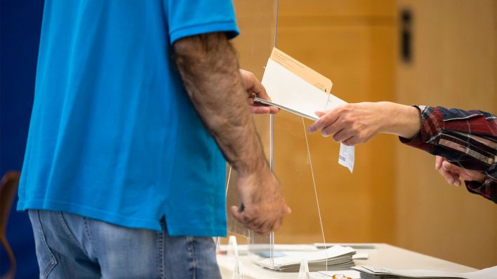 Ein Wahlberechtigter erhält am 26.09.2021 einen Stimmzettel in Berlin (Bild: imago images/Emmanuele Contini)
