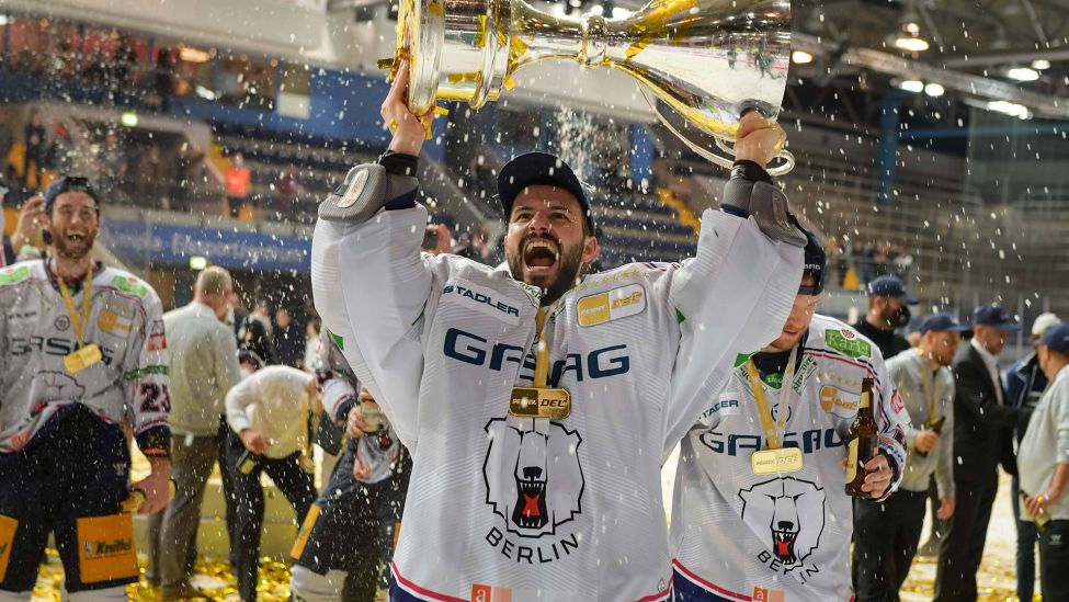 Eisbären-Spieler Mathias Niederberger hebt den Pokal in die Luft (Imago Images/Passion2Press)