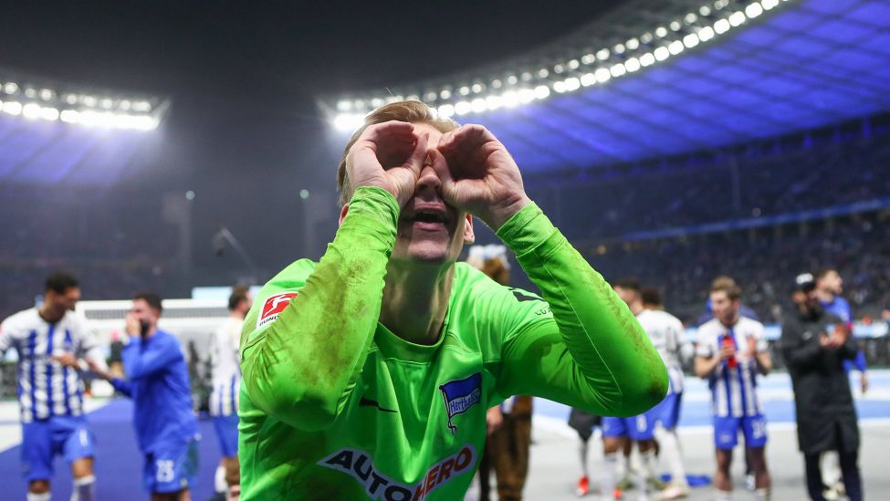 Hertha-Torhüter Oliver Christensen formt mit seinen Händen eine Brille und schaut in die Ostkurve des Olympiastadions (Imago Images/Jan Huebner)