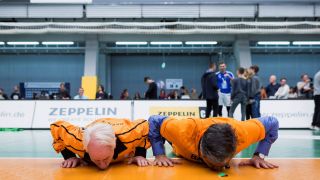 Günter Trotz und Kaweh Niroomand küssen den Hallenboden nach dem Sieg der Meisterschaft 2017 (Imago/Sebastian Wells)
