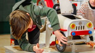 Ein Kind repariert ein Auto in der Ausstellung "Reparieren" im Deutschen Technikmuseum.(Quelle:Henning Hattendorf)