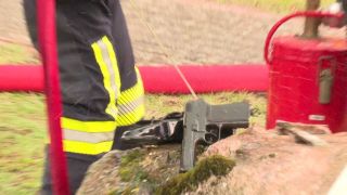 Ein Feuerwehrmann kühlt eine Waffe, die nach einer Explosion in einem Haus in Teupitz gefunden worden ist (Quelle: rbb)