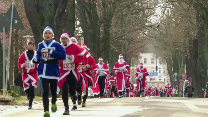 Teilnehmer:innen des Nikolauslaufs laufen eine Straße in Michendorf entlang (Bild: rbb)