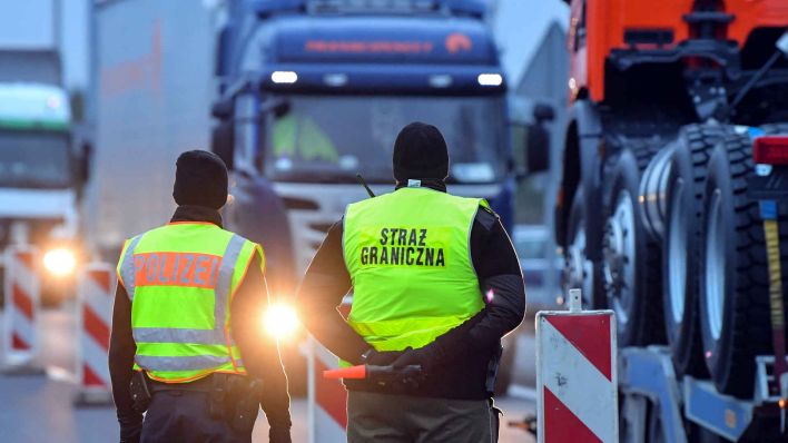 Ein Bundespolizist und ein polnischer Grenzschützer stehen an der Autobahn A12 am ehemaligen Grenzübergang in Swiecko. (Foto: Patrick Pleul/dpa)