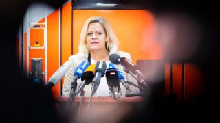 Bundesinnenministerin Nancy Faeser bei PK vor Krankenwagen (Quelle: dpa/Christoph Soeder)