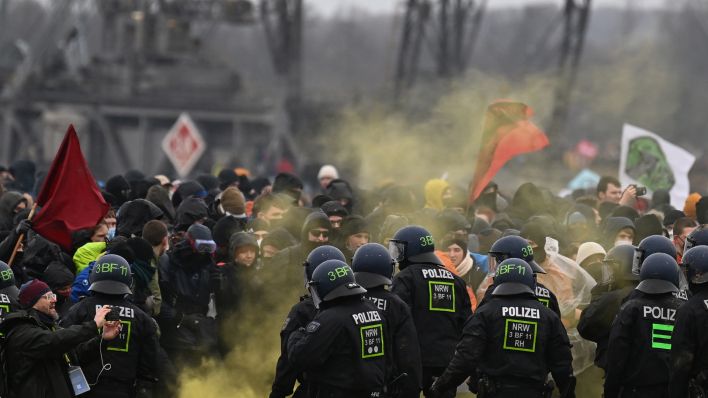 Demonstranten stehen am 14.01.2023 der Polizei in Lützerath gegenüber. (Quelle: dpa/Federico Gambarini)