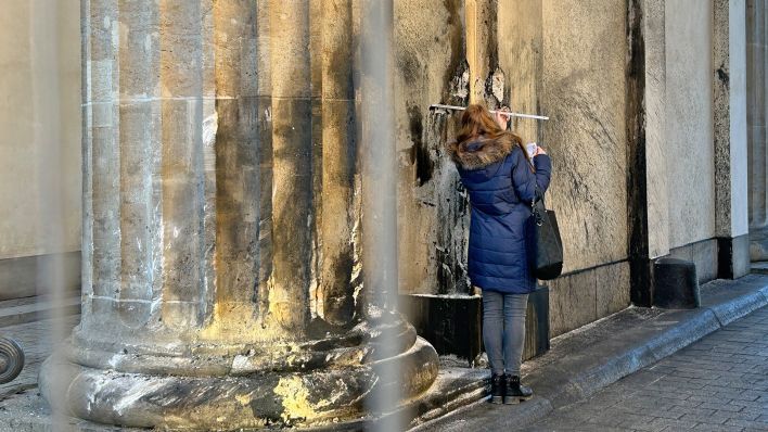 Eine Restauratorin stellt am 16.01.2023 die Schäden an einer Säule des Brandenburger Tores fest. (Quelle: dpa/Paul Zinken)