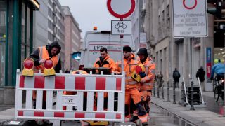 Arbeiter stellen am 30.01.2023 eine Absperrung an der Einfahrt zur Friedrichstraße, Ecke Leipziger Straße auf. (Quelle: dpa/Carsten Koall)