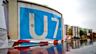 Archiv: Das Schild der U7 spiegelt sich in Berlin auf der Baustelle des U-Bahnhof Rudow. (Foto: Britta Pedersen/dpa)