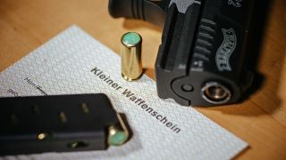 Symbolbild:Ein Kleiner Waffenschein liegt zwischen einer Schreckschuss-Pistole «Walther P22», einem Magazin und einer Knallpatrone.(Quelle:dpa/O.Killig)