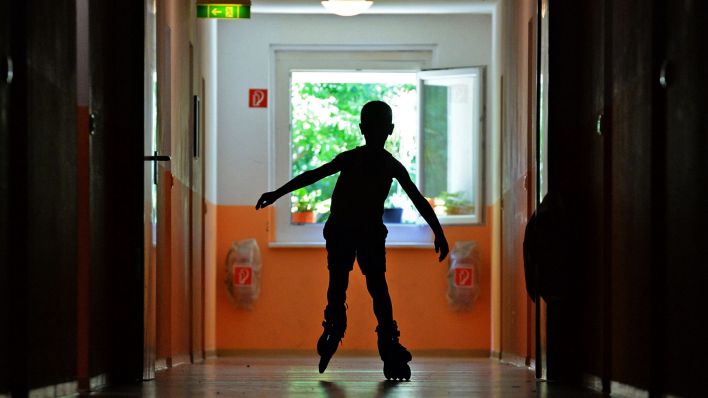 Symbolbild:Ein Junge fährt auf dem Flur einer Unterkunft mit seinen Skates.(Quelle:dpa/R.Hirschberger)