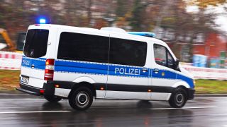 Symbolbild:Ein Mannschaftswagen der Polizei fährt bei einem Einsatz mit Blaulicht.(Quelle:dpa/W.Steinberg)