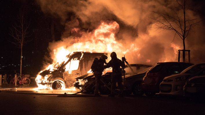 Archivbild: Feuerwehrkräfte löschen am 1. Januar 2023 einen brennenden PKW. (Quelle: dpa/M. Kuenne)